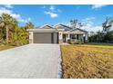 New construction home with a two-car garage and landscaped lawn at 1463 Jinright Rd, North Port, FL 34288