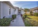 Pathway to the front entrance, featuring landscaping and a screened porch at 1570 Monarch Dr, Venice, FL 34293