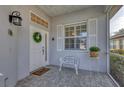 Front porch with white door, wreath, and a decorative bench at 1570 Monarch Dr, Venice, FL 34293