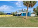 Blue house with a palm tree and spacious yard at 16834 Toledo Blade Blvd, Port Charlotte, FL 33954