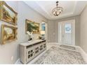 Elegant living room with a chandelier, decorative console table, and neutral color palette at 17120 Cresswind Ter, Bradenton, FL 34211