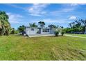 Newly renovated home with gray siding, spacious lawn, and a deck at 2726 Jerry Ave, Punta Gorda, FL 33950