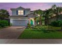 Two-story house with gray siding, stone accents, and a three-car garage at 3409 Anchor Bay Trl, Lakewood Ranch, FL 34211
