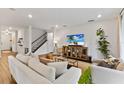 Bright living room with off-white sectional sofa and wood-look floors at 3409 Anchor Bay Trl, Lakewood Ranch, FL 34211