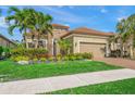 Tan house with tile roof, landscaping, and two-car garage at 3904 Waypoint Ave, Osprey, FL 34229