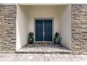 Double front doors with stone facade and potted plants at 4697 Antrim Dr, Sarasota, FL 34240