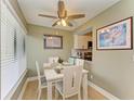 Bright dining area with white table and chairs, and view of kitchen at 4918 25Th W St # 102, Bradenton, FL 34207