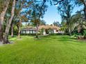 One-story home with a tile roof and green shutters, surrounded by trees at 5544 Ashley Pkwy, Sarasota, FL 34241