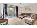 Living room with L-shaped sofa and balcony access at 5700 Bentgrass Dr # 16-211, Sarasota, FL 34235