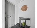Bright entryway with gray door, half-moon table, and decorative wall art at 650 Golden Gate Pt # 401, Sarasota, FL 34236
