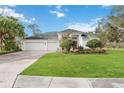 White two-story house with red door, landscaping, and a paved driveway at 6702 Pinehurst Pl, Bradenton, FL 34202