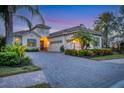 Luxury home with brick driveway, palm trees, and landscaped yard at 7504 Windy Hill Cv, Lakewood Ranch, FL 34202