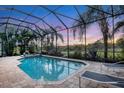 Enclosed pool and spa with lounge chairs and sunset view at 7504 Windy Hill Cv, Lakewood Ranch, FL 34202