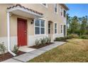Front entrance of condo with red door and walkway at 8150 Enclave Way # 104, Sarasota, FL 34243