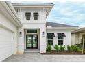 Home featuring manicured landscaping, a paved driveway, and a dark-colored glass paneled front door at 8376 Sea Glass Ct, Sarasota, FL 34240