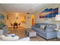 Open living area with gray sofa, dining table, and wood-look floors at 3223 Beneva Rd # 201, Sarasota, FL 34232