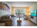 Bright living room with gray sofa, wood-look floors, and balcony access at 3223 Beneva Rd # 201, Sarasota, FL 34232