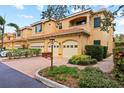 Tan two-story townhome with two-car garage, mailbox, and landscaping at 3665 Square West Ln # 13, Sarasota, FL 34238
