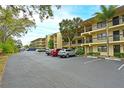 Condo building with parking lot and tropical landscaping at 425 30Th W Ave # C102, Bradenton, FL 34205