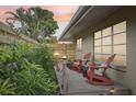 Wooden deck with red rocking chairs and tropical plants at 430 Beach Park Blvd, Venice, FL 34285