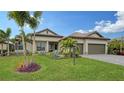 Landscaped one-story home with palm trees and two-car garage at 4810 Sparkling Sea Ln, Bradenton, FL 34211