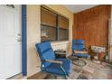 Small front porch with two blue chairs and a tiled floor at 5659 Saint Louis Ave, Sarasota, FL 34233