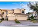 Two story tan house with a two car garage and lush landscaping at 7022 Prosperity Cir # 801, Sarasota, FL 34238