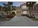 Tan three-story townhome with two-car garage at dusk at 8120 Enclave Way # 101, Sarasota, FL 34243