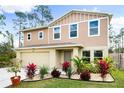 Two-story house with a tan exterior, landscaped yard, and driveway at 1379 E Price Blvd, North Port, FL 34288