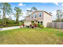 Two-story house with a tan exterior, wooden fence, and landscaped yard at 1379 E Price Blvd, North Port, FL 34288