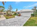 Single-story home with gray tile roof, white garage door, and stone driveway at 230 Vestavia Dr, Venice, FL 34292