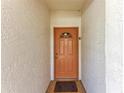 Orange door with a small window and doormat at 4366 Madeira Ct # 3356, Sarasota, FL 34233