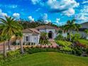 One-story house with lush landscaping and palm trees at 4986 Antiquity Way, Sarasota, FL 34240