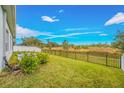 Spacious backyard with a grassy lawn, privacy fence, and mature trees at 6609 114Th E Ave, Parrish, FL 34219