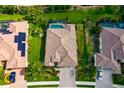 Aerial view of a home showing its tile roof, backyard pool, landscaping, and solar panels on a neighboring property at 6630 Horned Owl Pl, Sarasota, FL 34241
