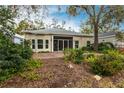 Home's back with screened porch and lush landscaping at 96 Tall Trees Ct, Sarasota, FL 34232