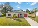 Single story home with red garage door and palm trees at 20096 Tappan Zee Dr, Port Charlotte, FL 33952