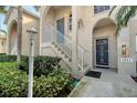 Condo building entry with stairs, lush landscaping, and security door at 4230 Castlebridge Ln # 1821, Sarasota, FL 34238