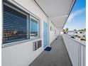 White hallway with light blue doors and white railings leading to condo units at 475 Benjamin Franklin Dr # 215, Sarasota, FL 34236