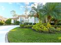 Beautiful front yard with lush green lawn and meticulously maintained tropical landscaping, enhancing curb appeal at 4837 88Th E St, Bradenton, FL 34211