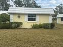 Quaint yellow house with white trim and a grassy yard at 5931 Tidewood Ave # 8, Sarasota, FL 34231