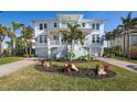 Beautiful two-story waterfront home with manicured lawn, lush landscaping, and a welcoming staircase at 718 Key Royale Dr, Holmes Beach, FL 34217