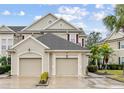 Tan two-story townhome with two-car garage and lush landscaping at 7946 Tybee Ct, University Park, FL 34201