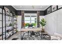 Bright home office with wainscoting, built-in shelving, and large window at 10129 Silent Night Ln, Sarasota, FL 34241