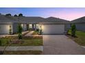 Evening view of two-unit home with attached garages at 25917 Bimini Sands Ct, Englewood, FL 34223