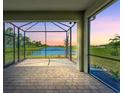 Spacious screened porch overlooking a pond at sunset at 25917 Bimini Sands Ct, Englewood, FL 34223