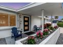 Inviting front porch with two blue chairs and lush flowers at 306 66Th St, Holmes Beach, FL 34217