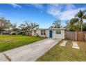 Charming single-story home boasting a lush green lawn, accented by a vibrant blue front door and mature landscaping at 3634 Lokai Pl, Sarasota, FL 34232