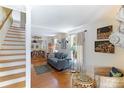 Bright and airy living room with hardwood floors, stairs to the second floor, and dining room access at 409 Pine Ave, Anna Maria, FL 34216