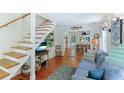 Cozy living room with hardwood floors, stairs to the second floor, and access to the dining room at 409 Pine Ave, Anna Maria, FL 34216